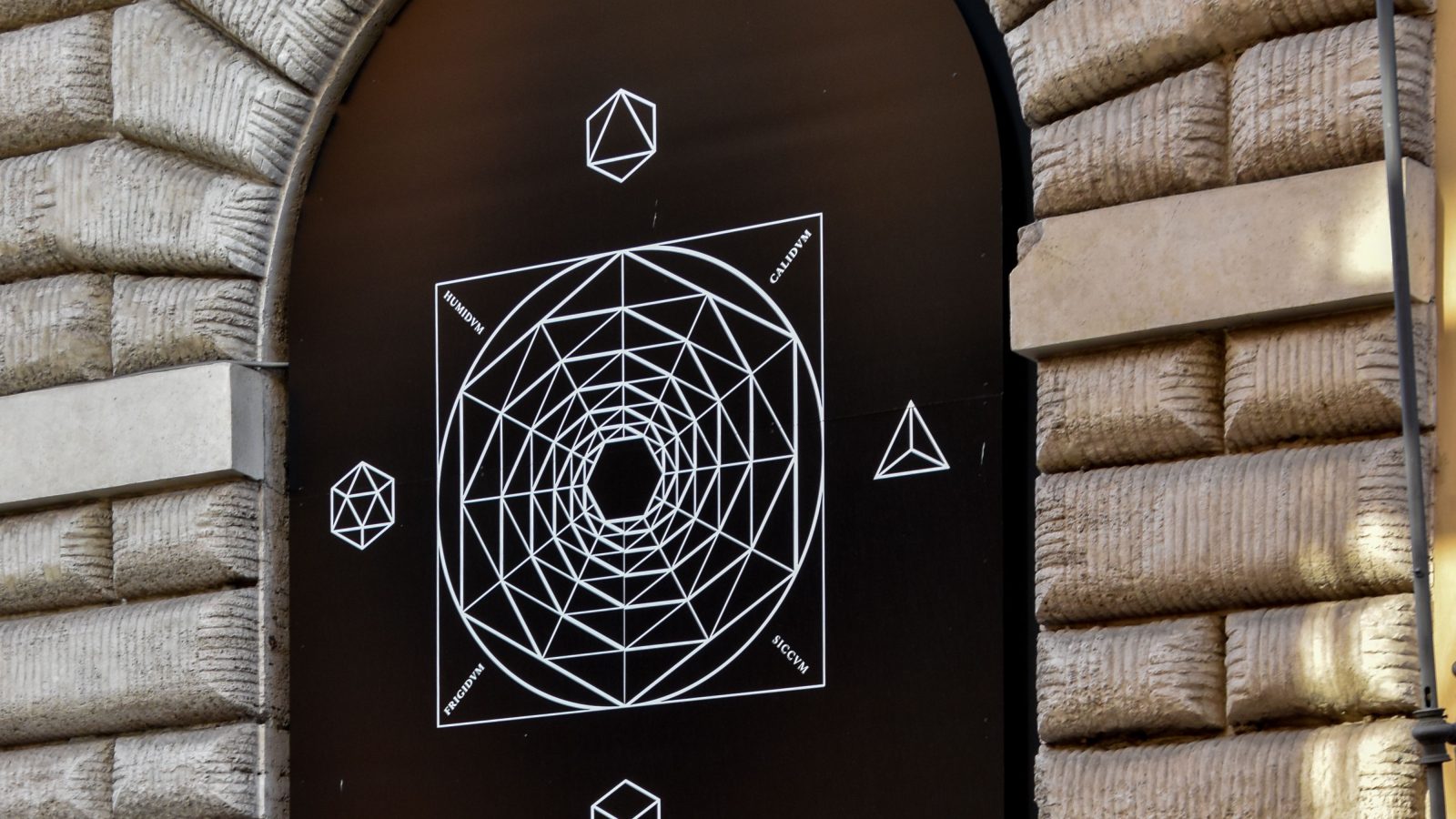Geometric mural inside a stone arch